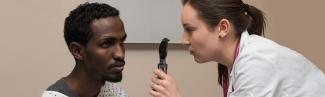 一名医师助理学生在病人的眼睛上练习使用检眼镜